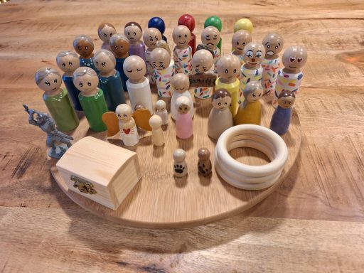 Familie opstelling Houten figuren in verschillende kleuren en vormen op een ronde houten schijf.